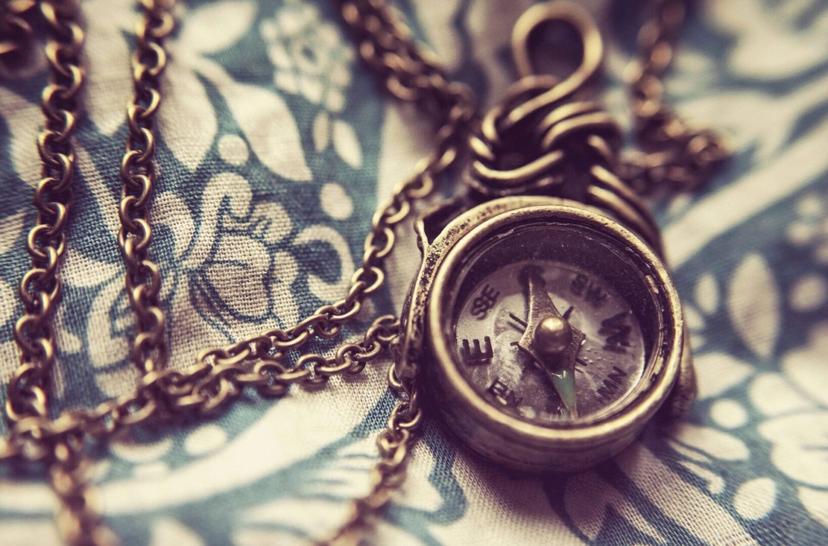 A close up of a compass on a chain